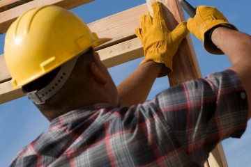 Photo of construction worker hammering wood frame