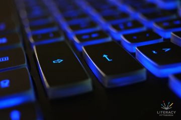 A computer keyboard backlit in blue