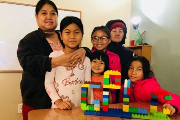 Family of six with a colorful children's block tower